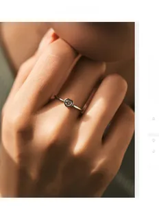 Close-up of minimalist S925 silver heart ring with sparkling moissanite on model hand