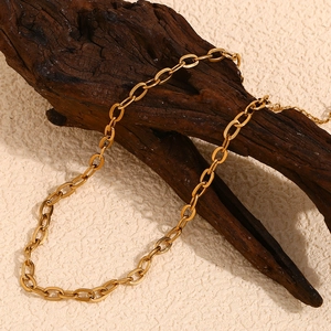 Detailed close-up of 18K gold-plated O-chain necklace on vintage wood texture