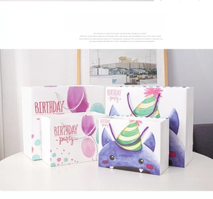 Detail view of cartoon monster birthday gift bags with woven rope handles and vibrant prints