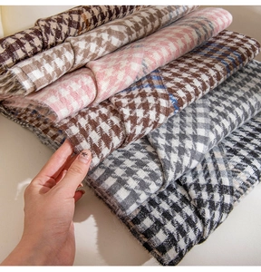 Macro shot of layered houndstock scarves with fringed edges in various soft color palettes