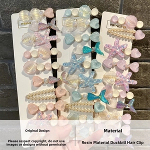 Detail of ocean-themed resin hair clips featuring shell, starfish, and fish tail motifs