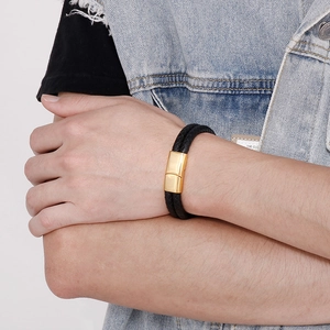 Close-up of men's double-layer braided black leather bracelet with a gold magnetic clasp
