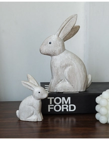 Detailed texture of rustic grey rabbit figurines set on dark wooden surface for home decor