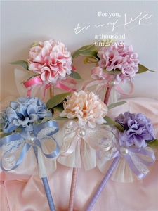 Close-up of elegant floral ball ballpoint pens with lace ribbons and faux pearls