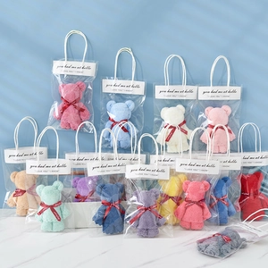 Colorful coral fleece bear towels in gift bags for wedding and party favors