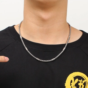 Collier à maillons cylindriques en acier inoxydable argenté porté sur un mannequin