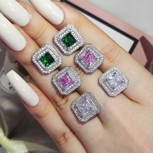 Macro detail of square zircon stud earrings in green, pink and white with halo setting