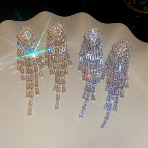 Macro shot of gold and silver rhonbus tassel earrings with sparkling cubic zirconia