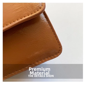 Detail shot of brown pleated leather texture with precise stitching on a stylish handbag