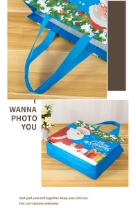 Detail of blue non-woven Christmas gift bag handle and Santa Claus printing