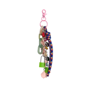 Dettaglio di ciondolo per borsa fai-da-te con resina rosa e verde, metallo e corda intrecciata