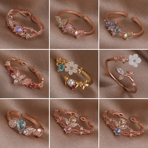 Luxury pearl and zircon rings with shell flower designs on brown silk fabric