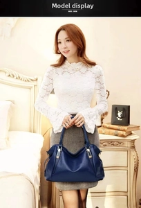 Elegant Asian model carrying a large capacity navy blue soft leather handbag at home