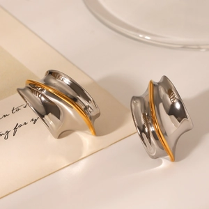 Macro detail of two-tone stainless steel earrings with gold and silver polished finish