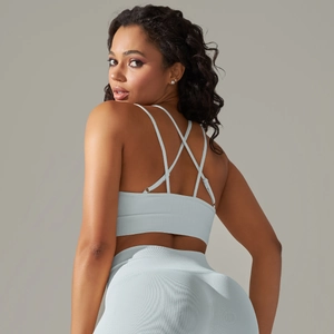 Detail of cross back straps and seamless knit texture on a light grey-blue sports bra