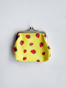 Detail of yellow fabric coin purse with red strawberry prints and retro metal clasp