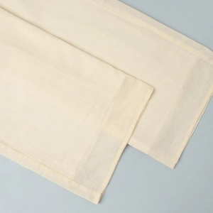 Close-up of beige cotton linen pants hem showing high-quality stitching and fabric texture