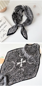 Macro detail of pleated silk scarf featuring paisley patterns and wavy scalloped edges