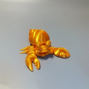 Detailed macro view of a 3D printed hermit crab toy in vibrant golden plastic finish