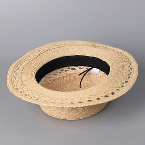 Handwoven natural raffia straw sun hat with elegant hollow patterns and wide brim
