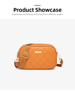 Detail of orange quilted crossbody bag with gold-tone hardware and wide brown strap