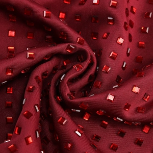 Détail du tissu de robe de soirée rouge foncé avec paillettes brillantes et plis élégants