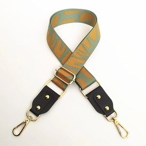 Adjustable wide canvas bag strap with green geometric pattern and gold hardware
