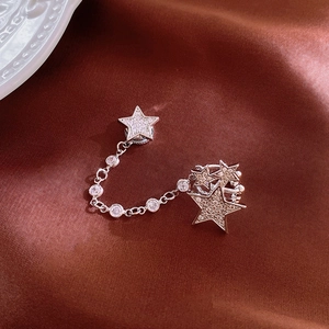 Silver magnetic star ear cuff with zircon crystals on a luxury silk background