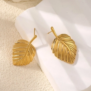 Elegant gold ginkgo leaf stud earrings with detailed vein texture on a modern pedestal
