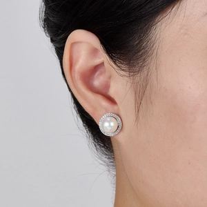 Elegant S925 sterling silver pearl stud earrings with sparkling cubic zirconia halo on model
