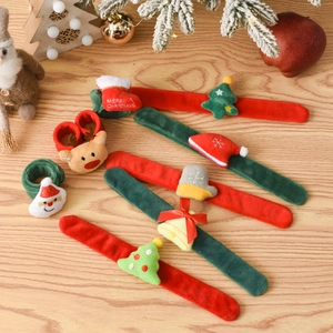 Detailed view of Christmas slap bracelets with plush Santa and Reindeer on wood background