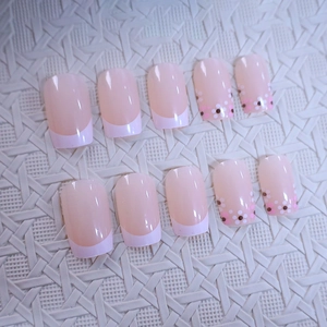 Pink French press-on nails with white tips and delicate brown floral patterns