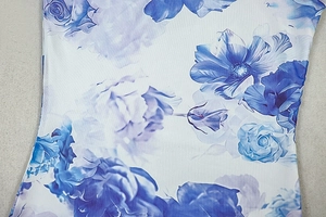 Close-up of blue and white floral print on soft stretch fabric with rose pattern detail