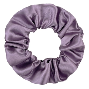 Detailed close-up of a purple satin scrunchie with soft silk texture and elegant folds