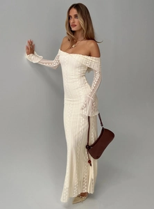 Detailed close-up of intricate white lace texture on an elegant off-shoulder maxi dress