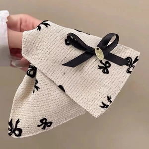 Detail of elegant beige tweed hair clip with black embroidery and gold metal accent