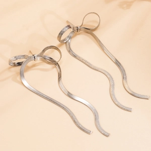 Detailed close-up of silver bow earrings with elegant long snake chain tassels