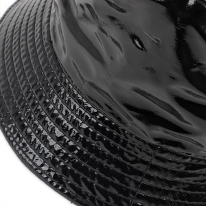 Detailed close-up of glossy black patent leather bucket hat with neat parallel stitching