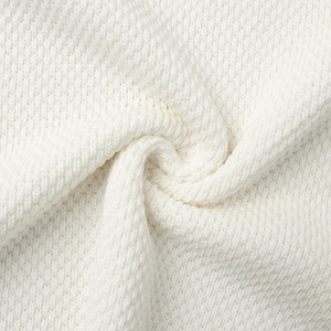 Macro detail of high-quality white knitted fabric showing the soft woven texture and fiber