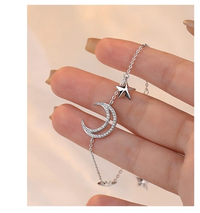 Detailed close-up of a silver moon and star bracelet with sparkling zircon stones on a wrist