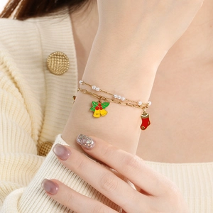 Detail of Christmas double-layer bracelet with bell and stocking charms on wrist