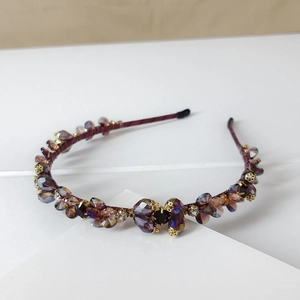 Close-up of handmade crystal headband featuring deep purple beads and gold metal accents