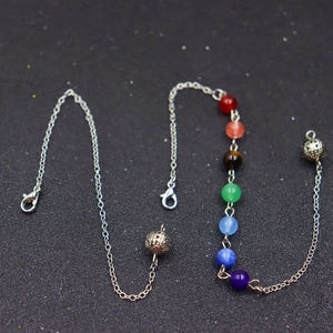 Chakra healing necklace with seven colorful beads and hollow metal spheres on silver chain