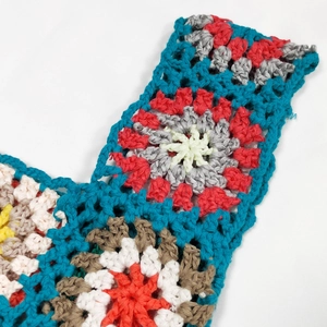 Close-up of handmade crochet bag showing colorful granny square patterns and stitching