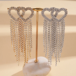 Elegant heart tassel earrings with sparkling rhinestones displayed on a metal stand
