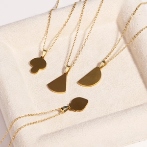 Set of four gold-plated titanium steel necklaces with colorful fruit pendants on velvet