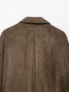 Close-up of the collar and back seam stitching on a dark brown suede jacket