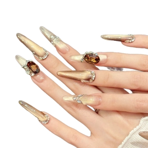 Luxurious champagne gold cat-eye press-on nails with amber gemstones and sparkling rhinestones