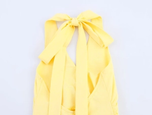 Detailed close-up of a bright yellow halter neck dress with an elegant back tie-up bow