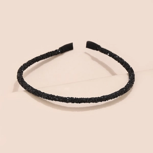 Detail shot of a black glitter headband for women featuring a slim design and fabric ends
